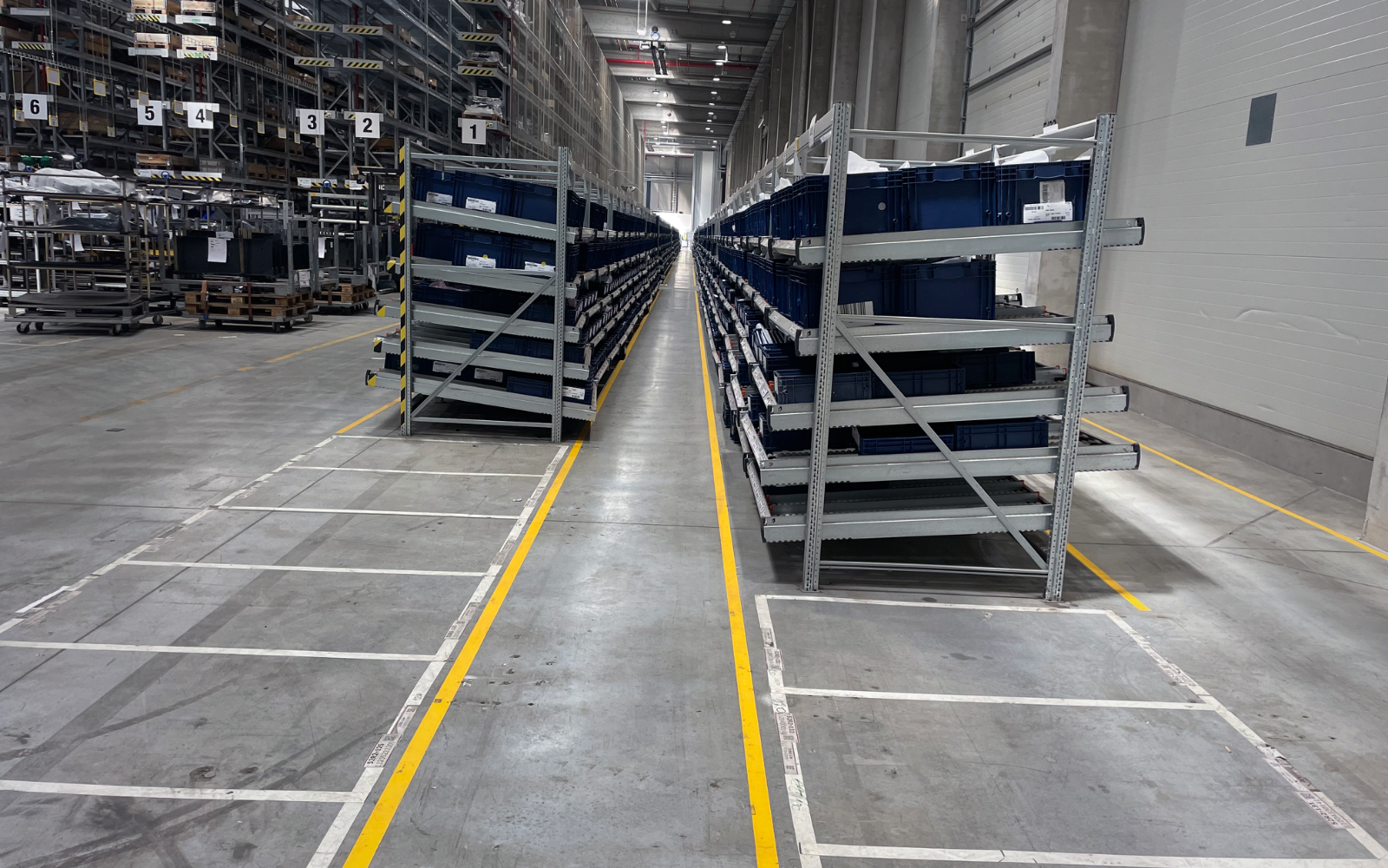 Gravity flow-rack aisle with parts bins